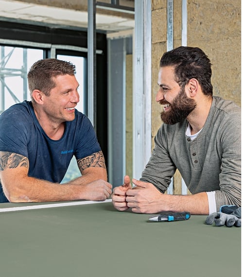 Wykonawcy na budowie pracujący z zieloną płytą